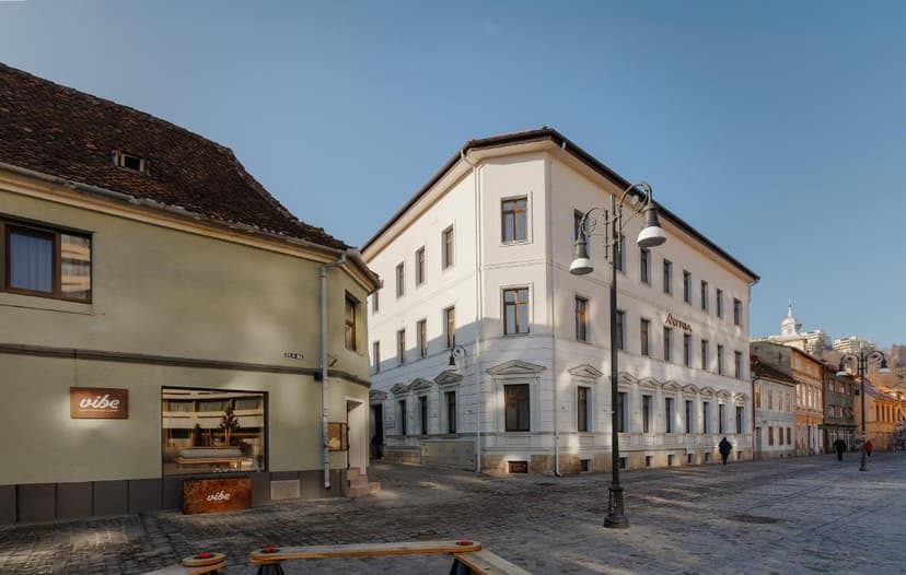 Hotel Atria building on cobblestone street corner with historic architecture and clear blue sky.