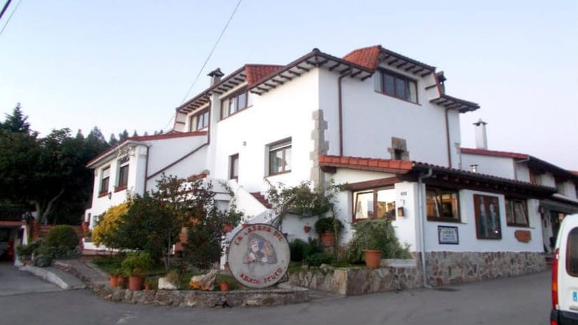 Albergue de Peregrinos de Güemes, a white building with a red tile roof and stone accents.