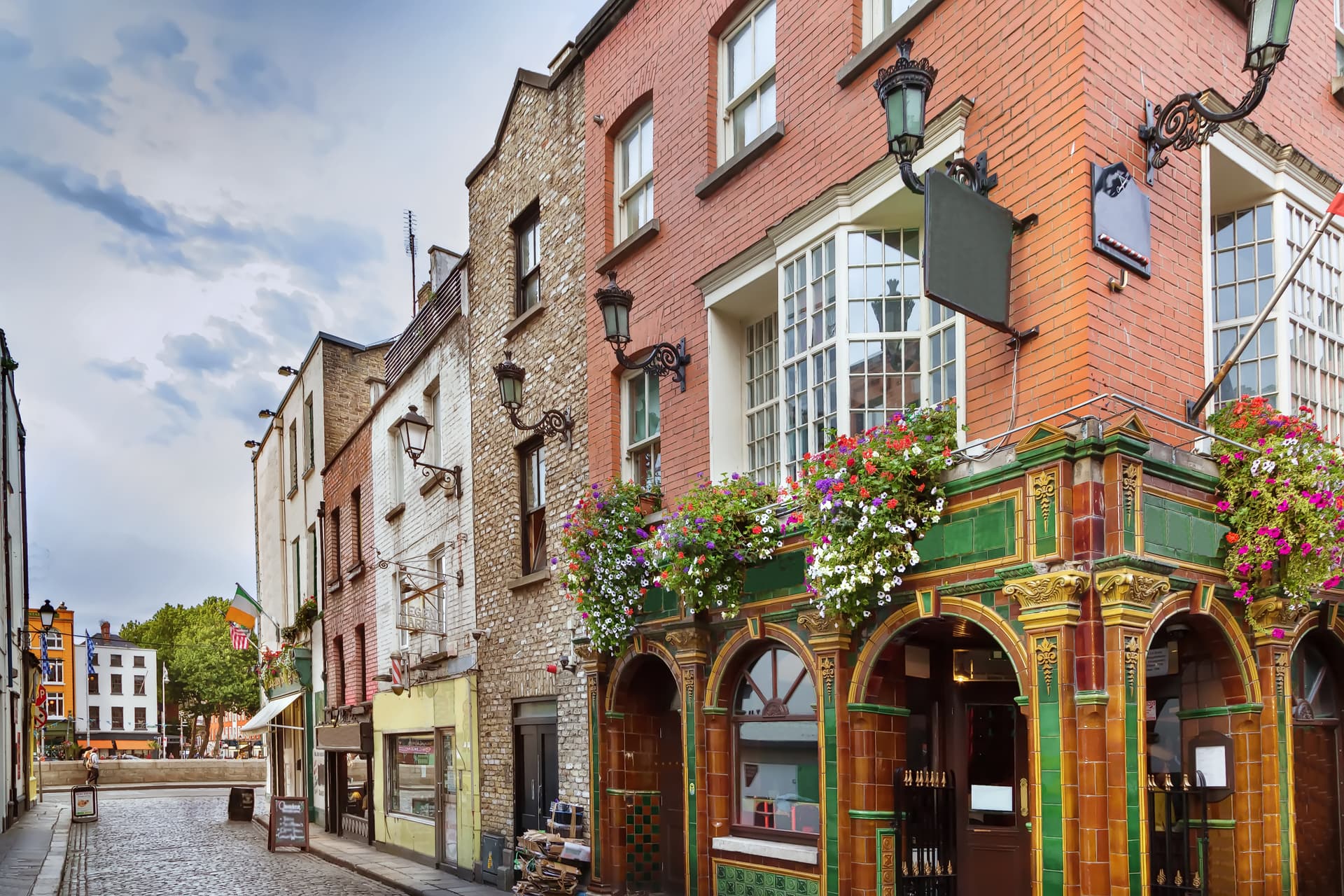 Cobblestone street in Dublin with historic brick buildings and colorful flower boxes.