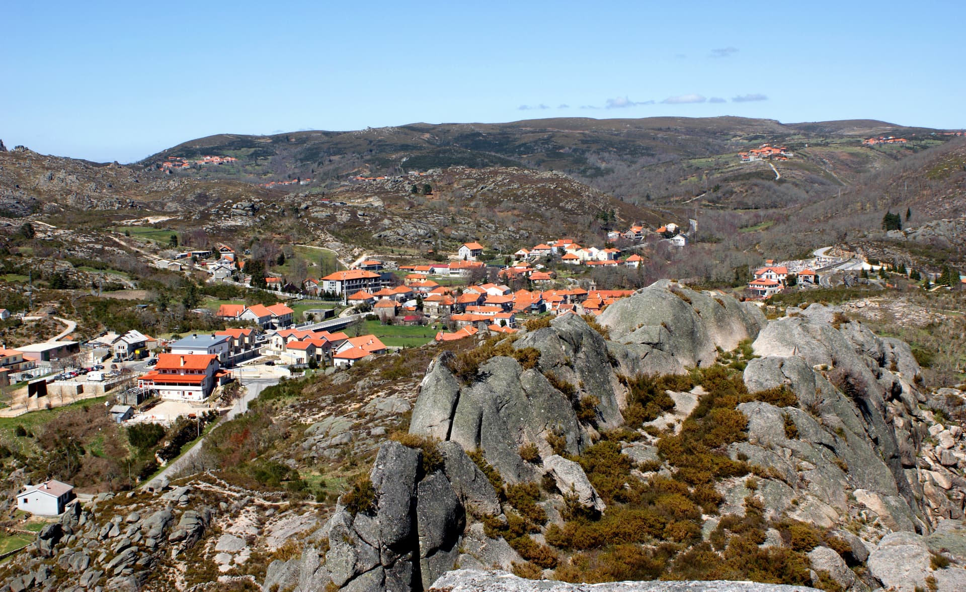 Castro Laboreiro village nestled in rocky, arid hills under a clear blue sky in northern Portugal.