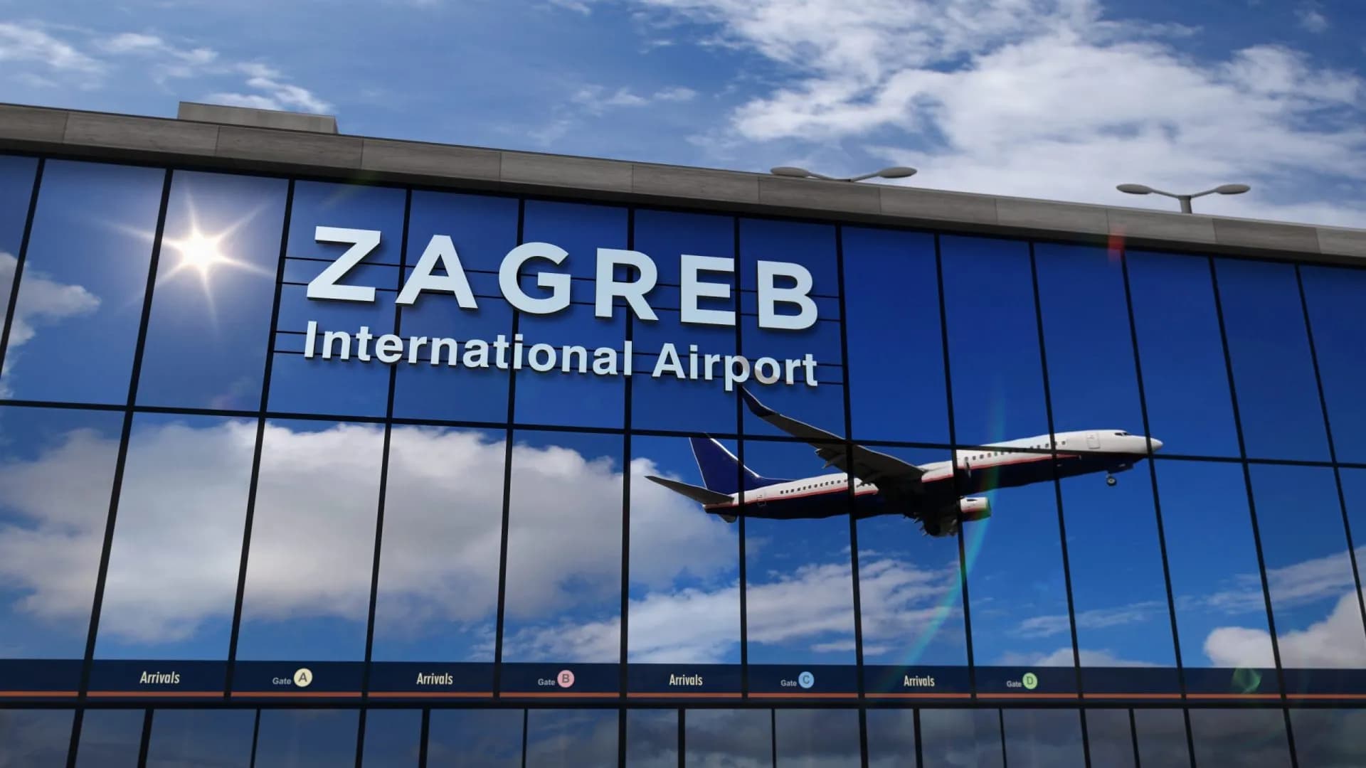 Airplane landing reflected in Zagreb International Airport glass facade under blue sky.