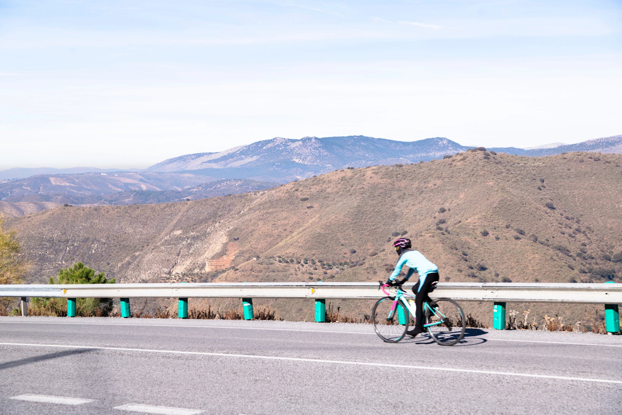 Motorväg i Spanien med cyklist mot bergen Sierra Nevada
