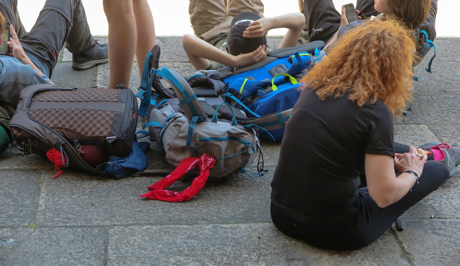 various backpacks lying on the pavement