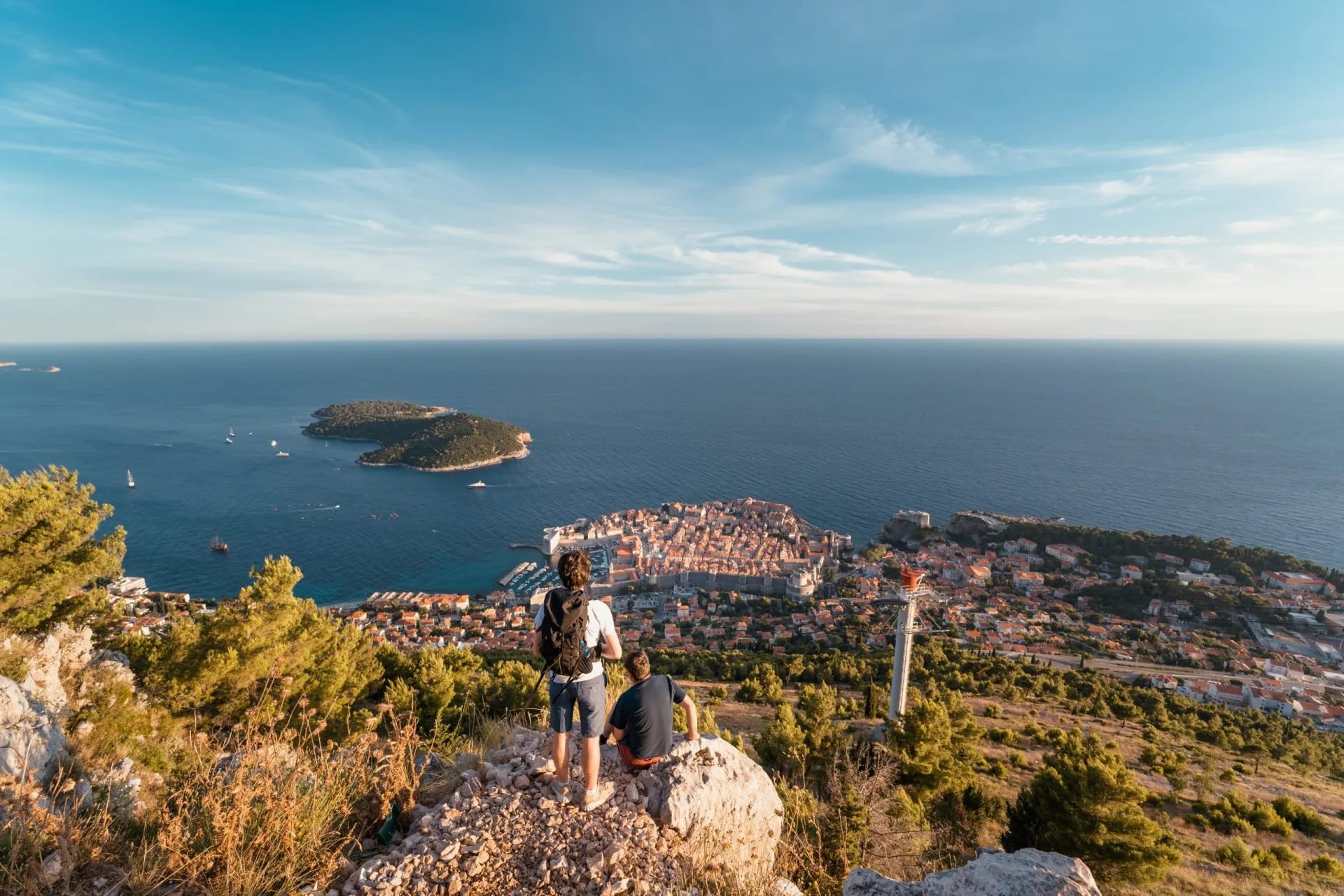 Hikers overlooking Dubrovnik Old Town and Lokrum Island from Fort Imperial trail.
