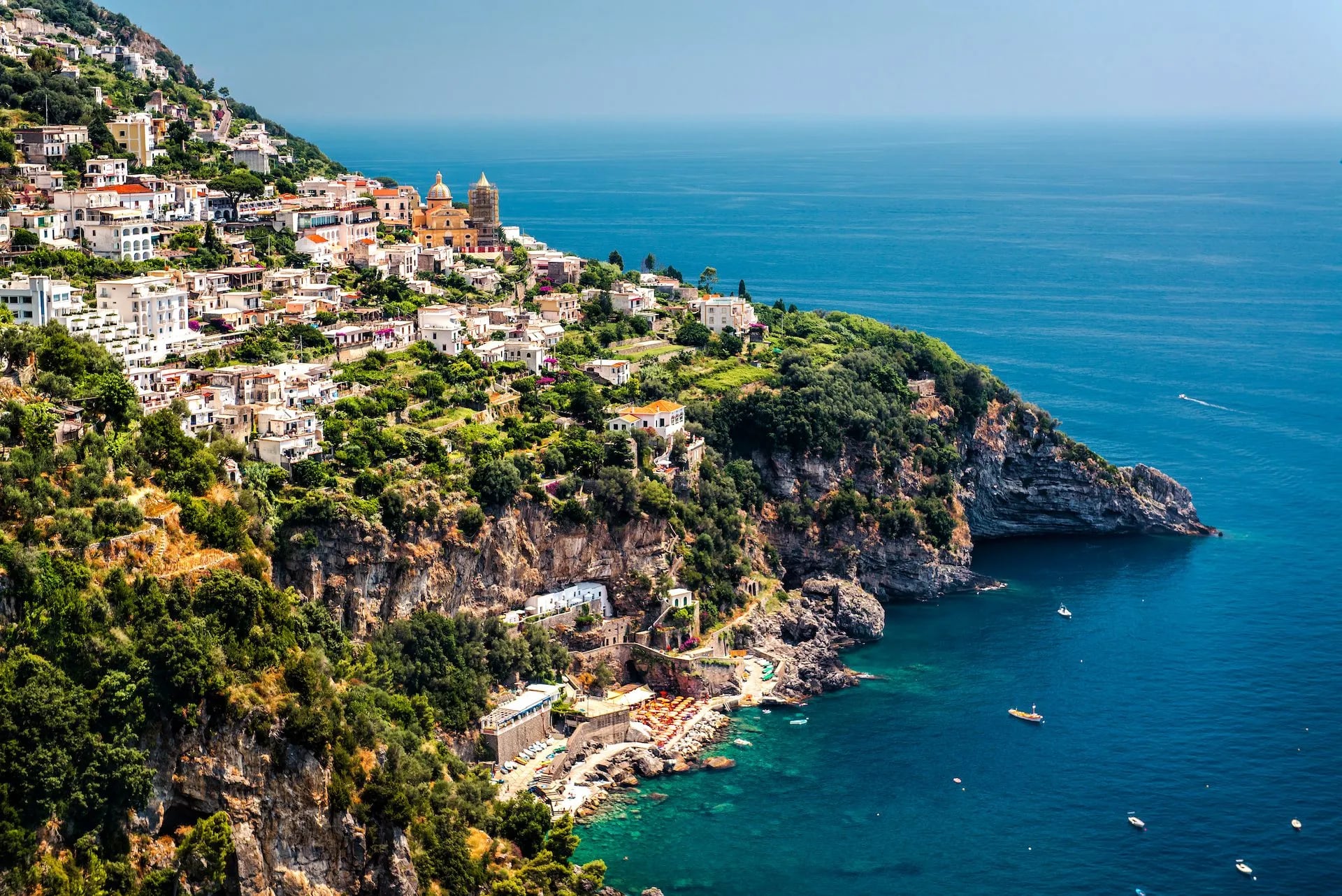 View of Praiano town built on a steep cliff overlooking the deep blue Tyrrhenian Sea.
