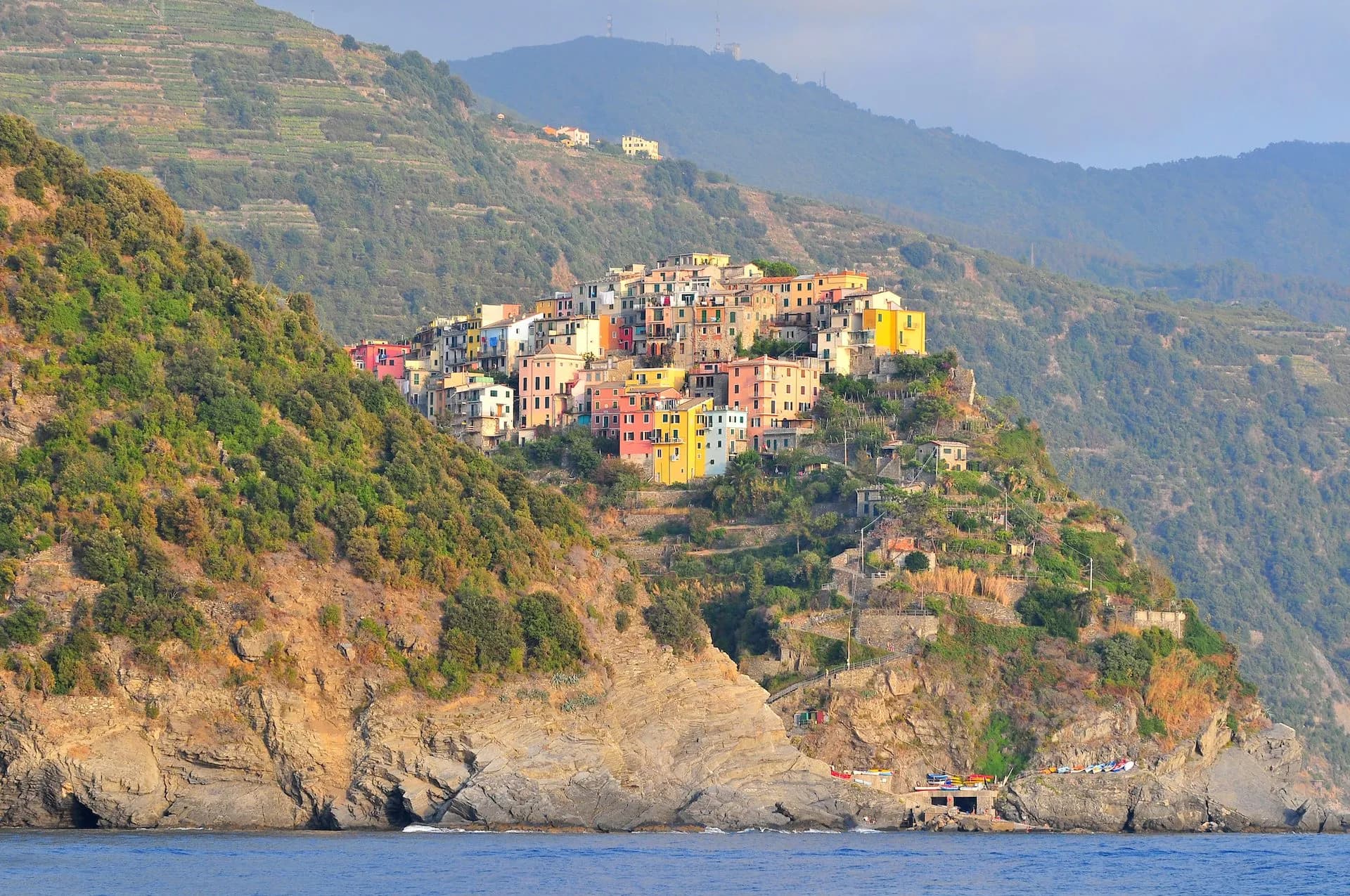 Colorful village perched on steep, terraced cliffs above the blue sea, Corniglia.