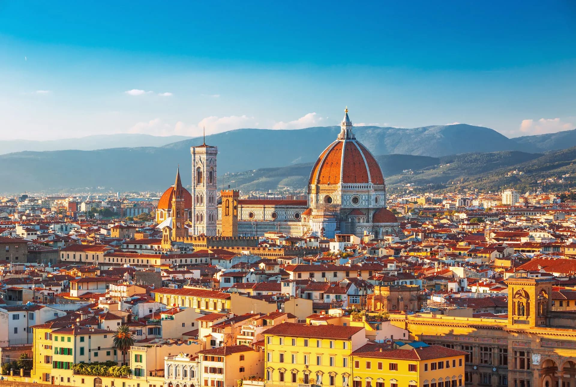 Florence cityscape with Duomo dome and Giotto's Campanile against hazy mountains