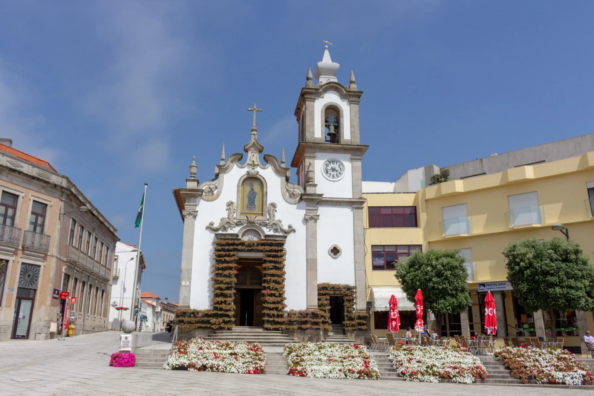 Vila Praia de Ancora / Caminha / Portugal - July 8, 2020: Flowers decorating the outside of the grand old church Capela de Nossa Senhora da Bonança, the chapel dedicated to Our Lady of Bonanca.