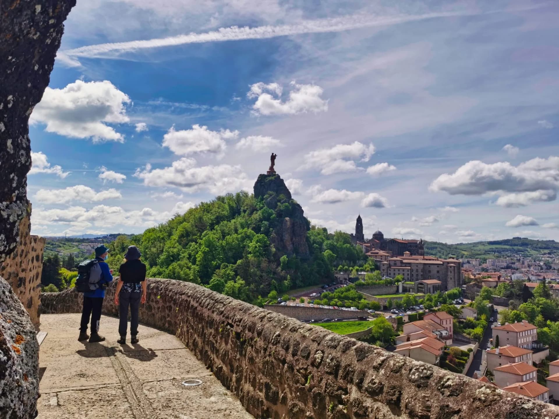 Pilgrims looking at the magnificent view over Le Puy en Velay, departure of the camino de santiago. France.