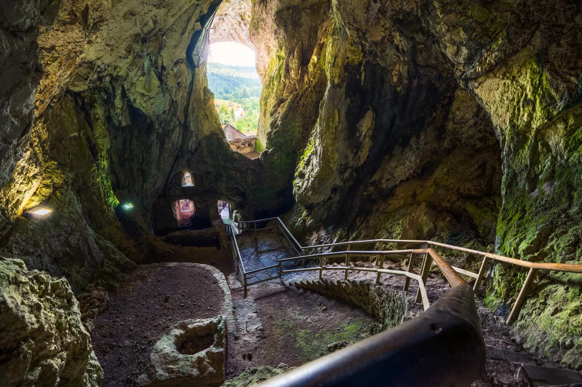 Stone staircase inside the cave interior of Predjama Castle in Slovenia, looking toward the exit.