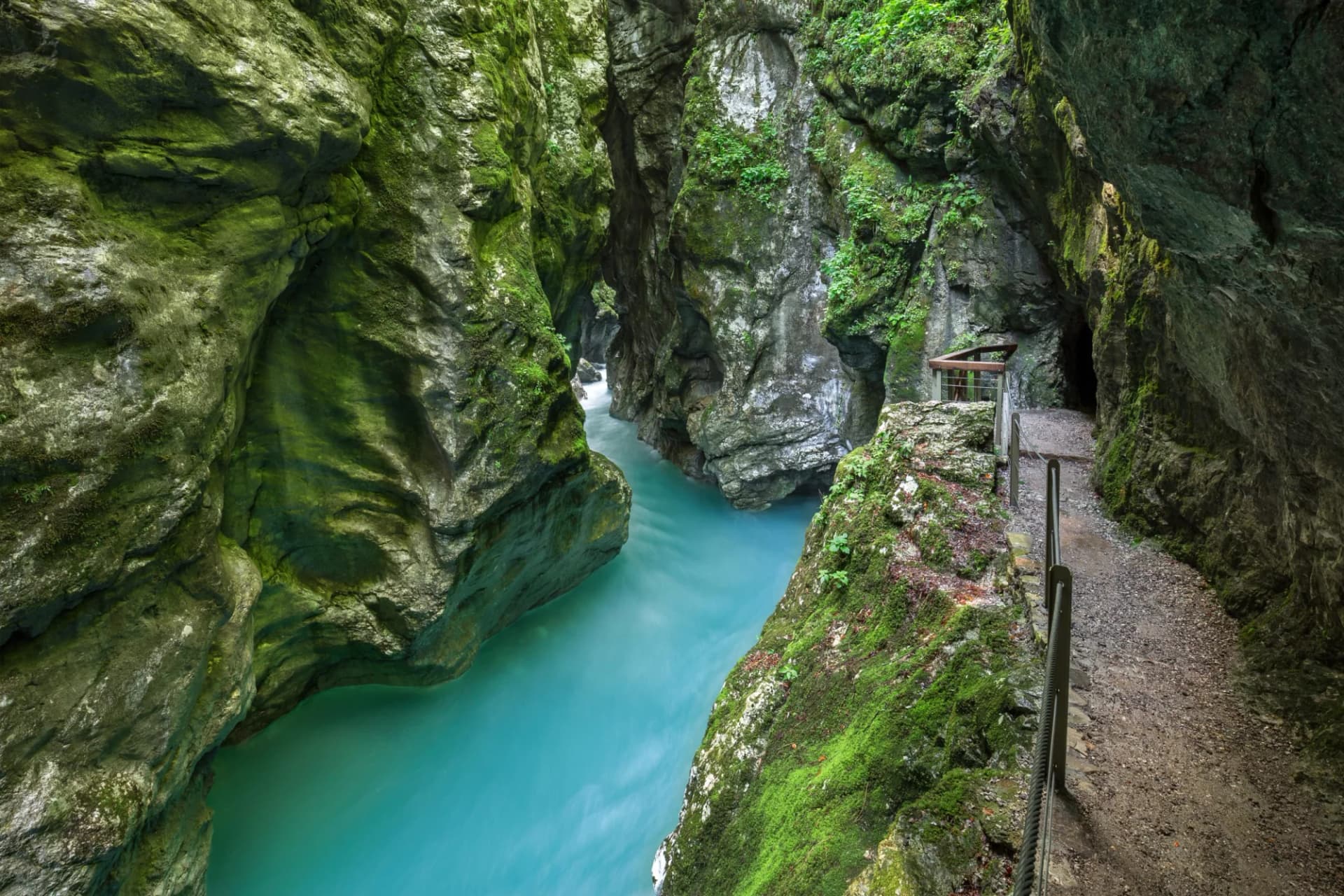 Hiking path along Tolmin Gorge in Triglav National Park with turquoise river below