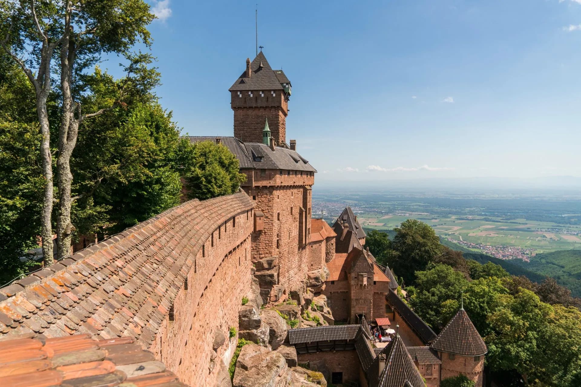 Château du Haut-Kœnigsbourg stone fortress with ramparts overlooking a vast green valley.