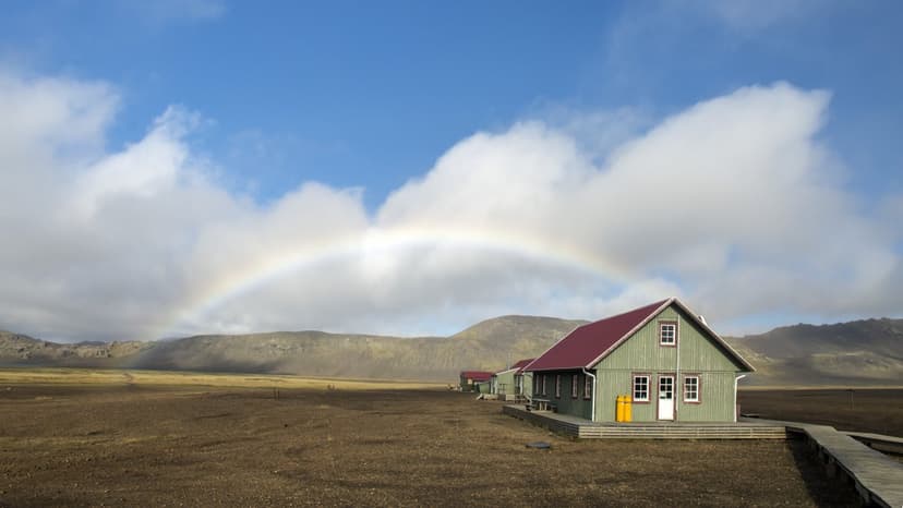 Álftavatn hut under a rainbow with barren mountains in the background
