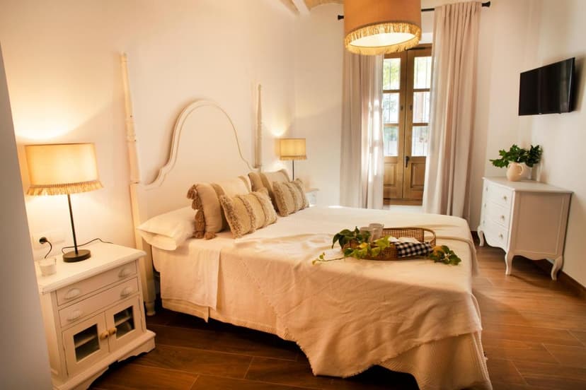 Bedroom in Casa Rural Candelas with white four-poster bed and wooden floors