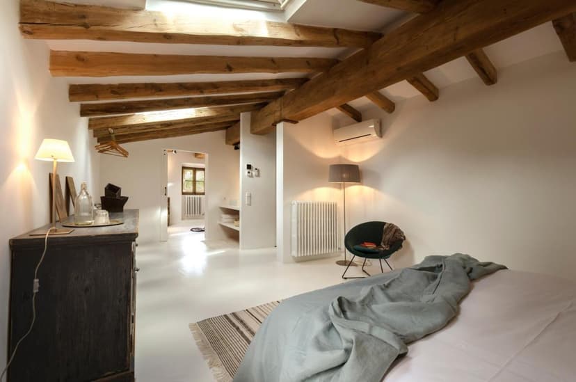 Bedroom in Agroturismo Son Viscos with exposed wooden beams and white floors