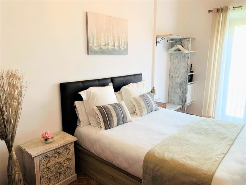 Hotel Casa Bougainvillea room with white bedding, patterned pillows, and bright natural light.