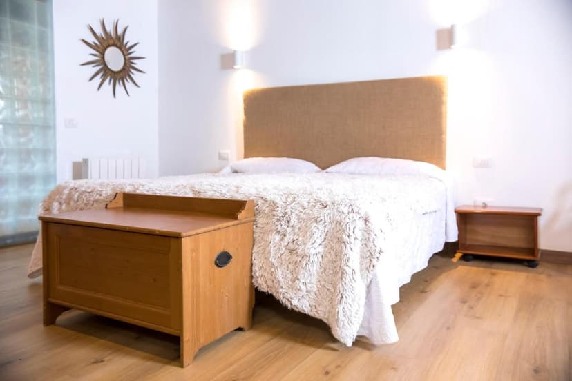 Bedroom in Hotel Rural El Refugio with wooden chest and sun mirror decor.