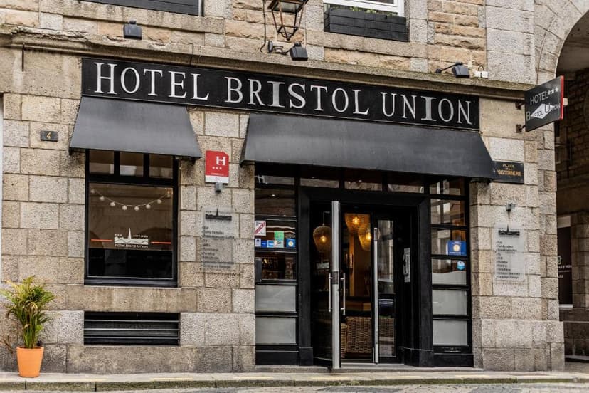 Hotel Bristol Union entrance with stone facade and black awnings in Intra Muros.