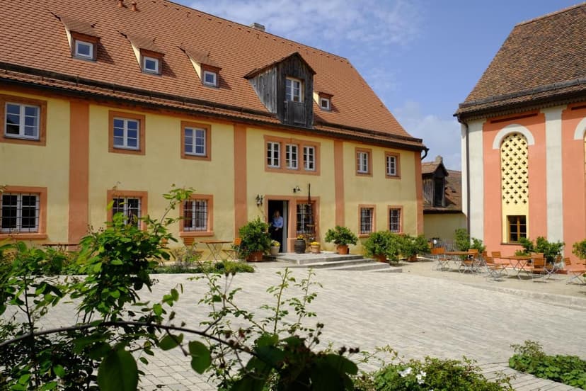 Hotel-Garni Gentner building with yellow facade and terracotta roof in a paved courtyard.