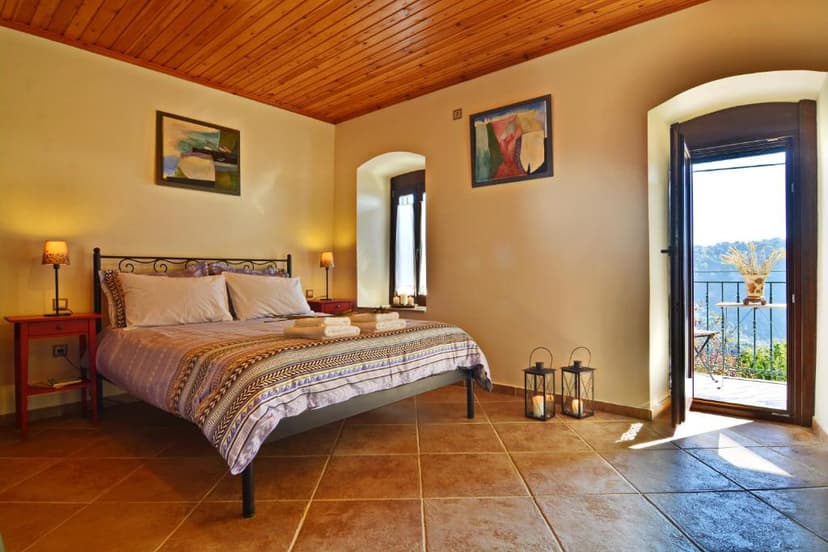 Gartagani Guest House bedroom with wooden ceiling and balcony view