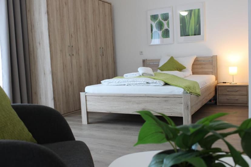 Bedroom in Greenapartment Kelheim with light wood furniture and green accents