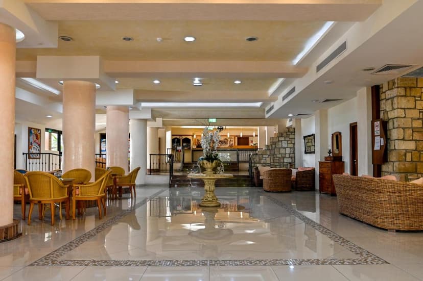 Spacious Veronica Hotel lobby with wicker seating, stone accents, and a central floral display.