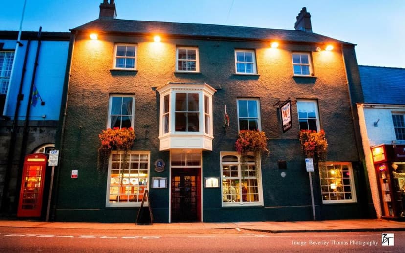 Old Kings Arms Hotel exterior at dusk with illuminated facade and traditional red telephone box