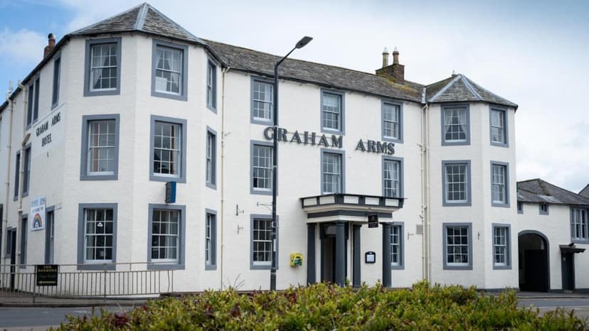 Graham Arms Hotel building with white stucco and dark trim under a cloudy sky