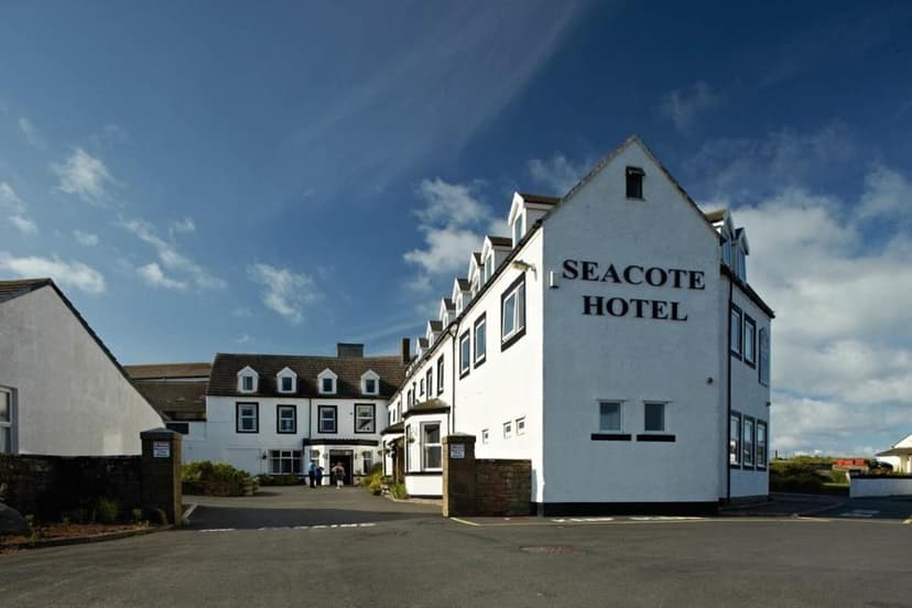 White Seacote Hotel building exterior under a blue sky with scattered clouds.
