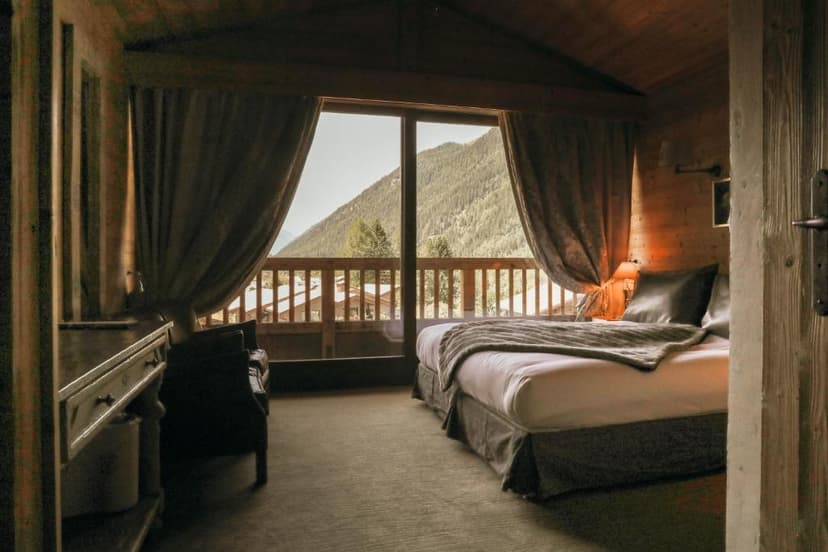 Cozy wooden chalet bedroom with mountain view balcony in Les Grands Montets.