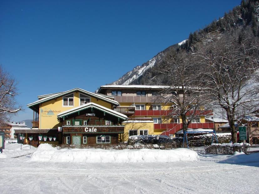 Hotel Lampenhäusl and cafe in snow-covered alpine village with forested mountain background