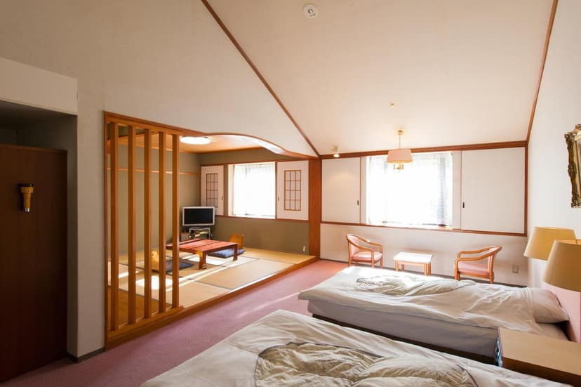 Twin beds and tatami seating area with low table in Watarase Onsen Hotel Sasayuri room.