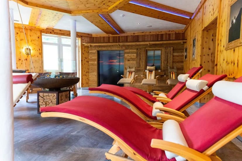 Relaxation room with red loungers, wood paneling, and a modern fireplace feature.