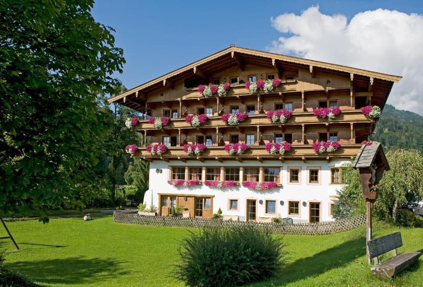 Hotel Gut Kramerhof building with wooden balconies and flower boxes on a sunny day.