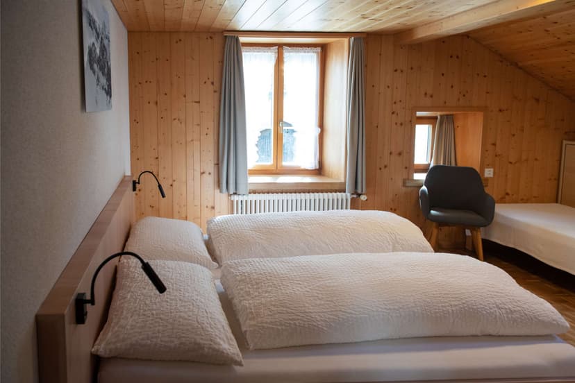 Cozy hotel room with wood paneling, white bedding, and window light in Segnes area.