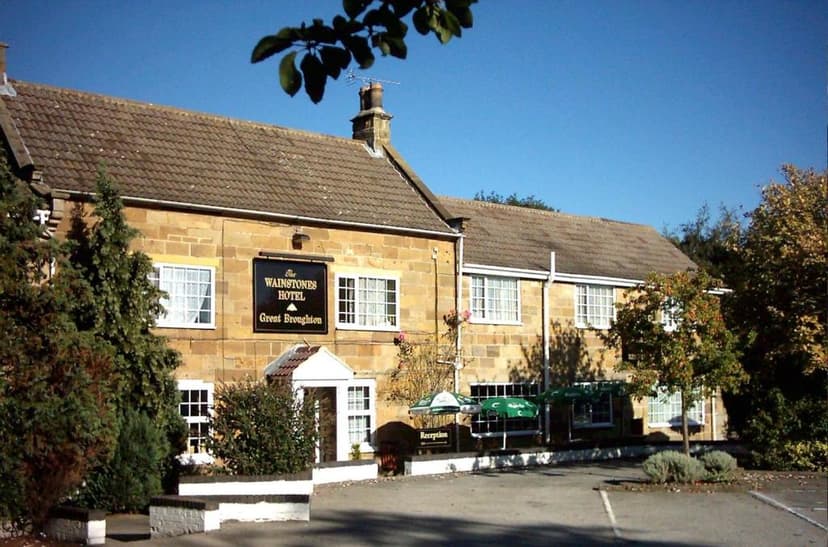 The Wainstones Hotel in Great Broughton with stone facade under a clear blue sky.