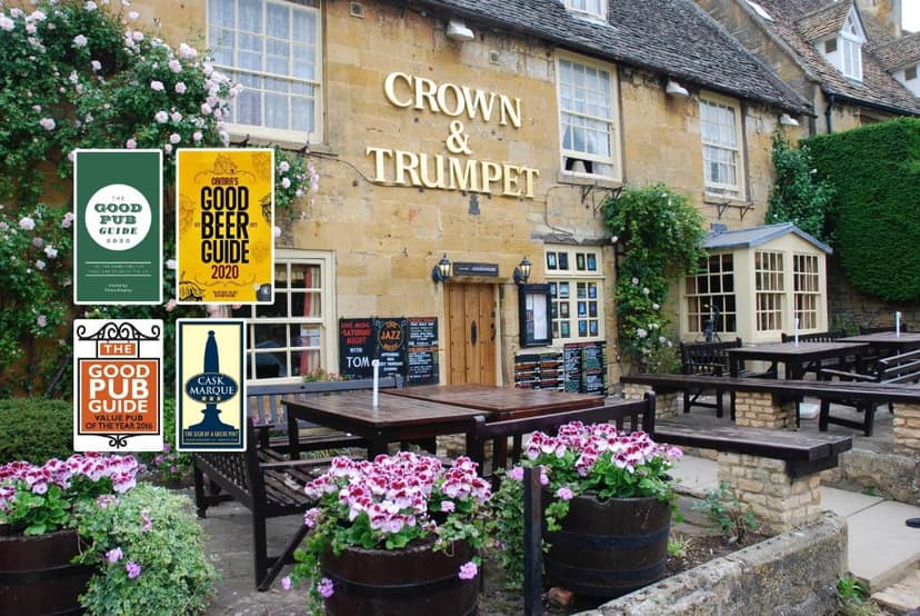 Crown & Trumpet Inn exterior with outdoor seating and pub guide awards.