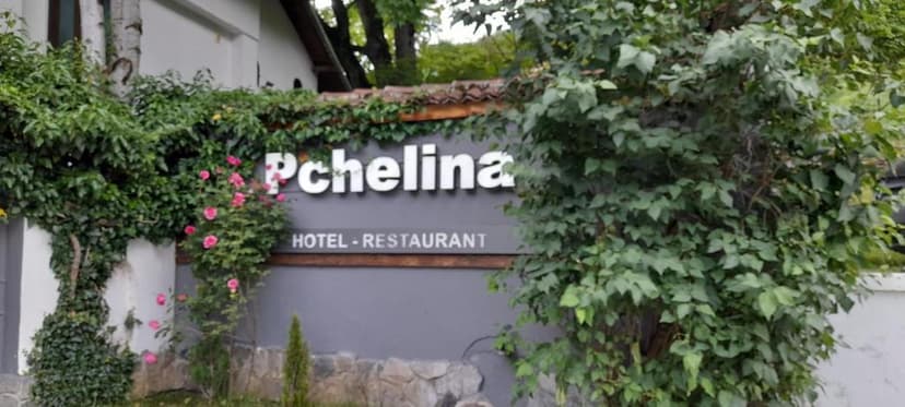 Pchelina Hotel - Restaurant sign surrounded by lush green ivy and pink roses.