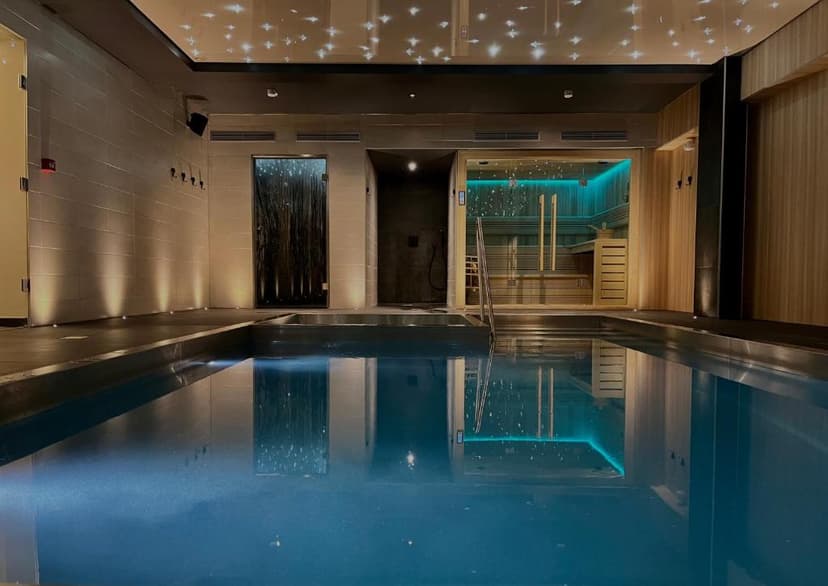 Indoor swimming pool area with a sauna, starry ceiling, and mood lighting at Hôtel Haut-Koenigsbourg.