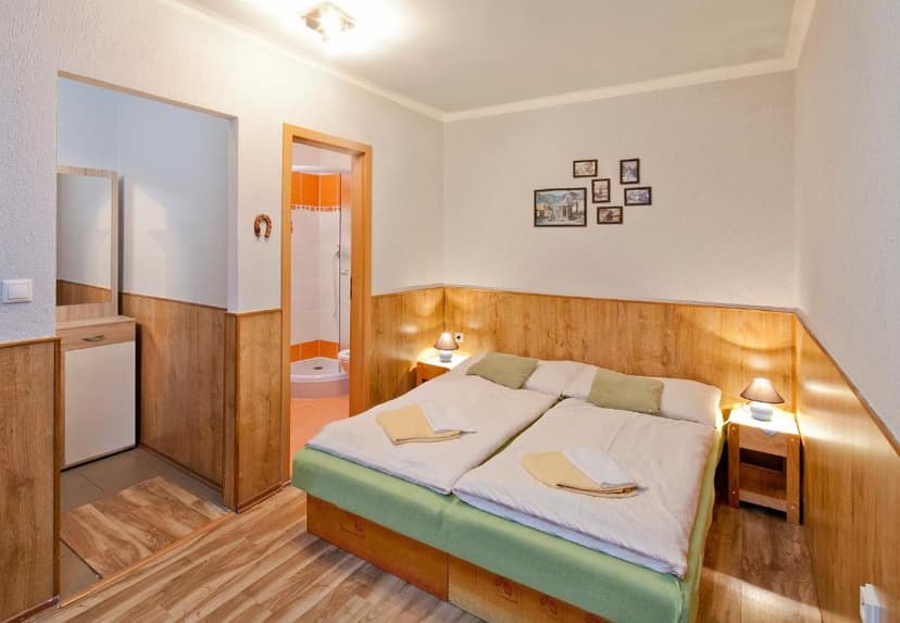 Bedroom with twin beds, wood paneling, and view into an orange-tiled bathroom.