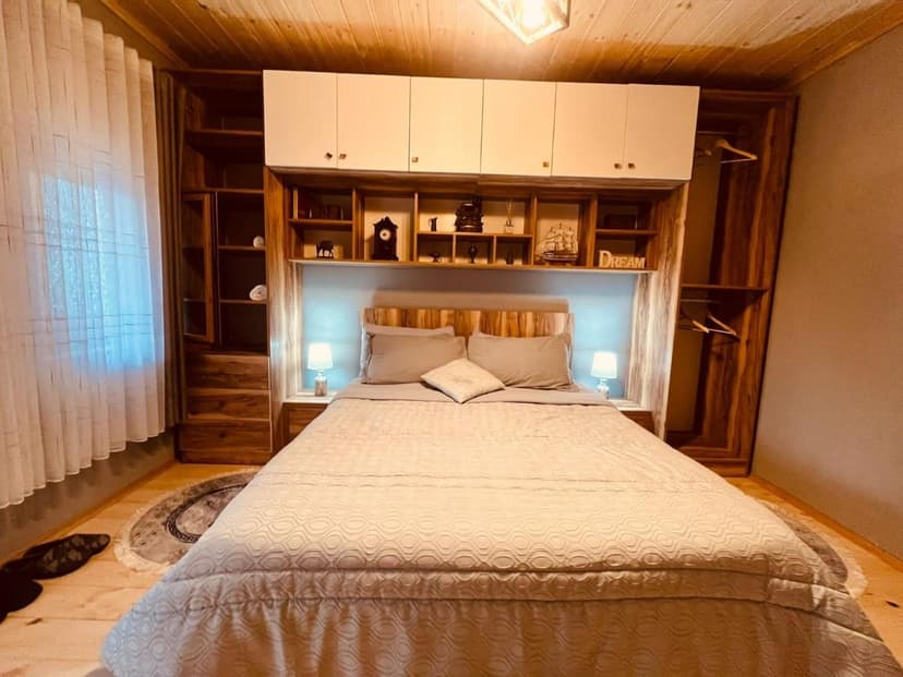 Cozy bedroom with wooden accents, built-in shelving, and a large bed in Guesthouse Gjin Thana.