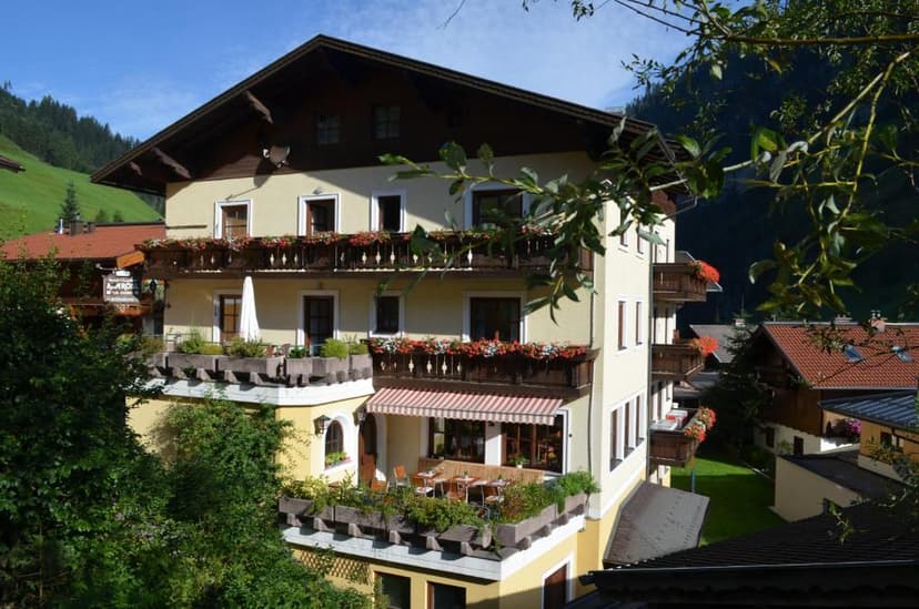 Landhotel Almrösl in Großarltal with balconies, flower boxes, and green mountainsides.