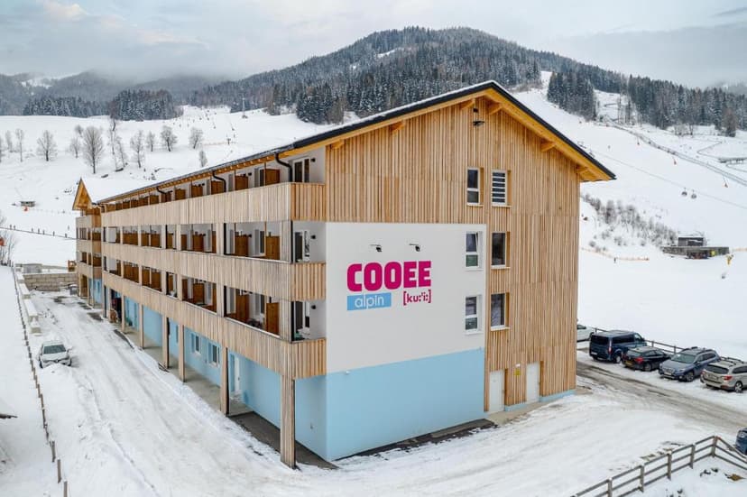 COOEE alpin Hotel Bad Kleinkirchheim in snow with ski slopes and forested mountains.