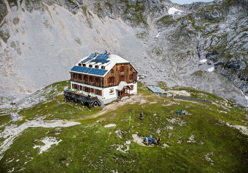 Guttenberghaus mountain hut with solar panels surrounded by rocky alpine terrain and hikers