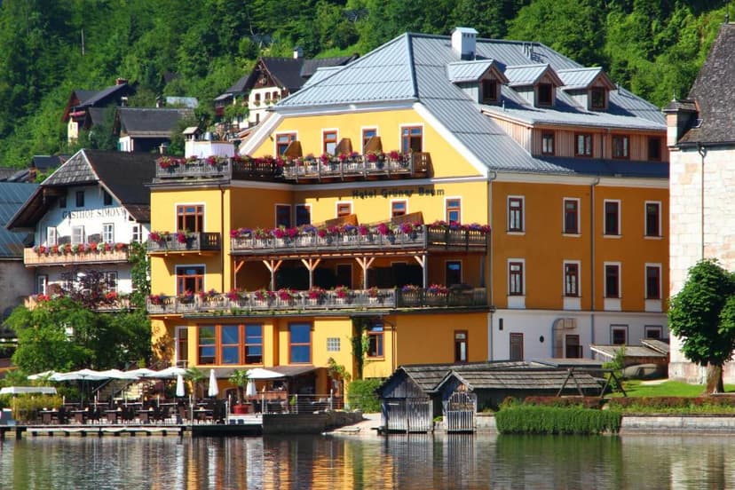 Hotel Grüner Baum on lake with outdoor dining and forested mountainside backdrop