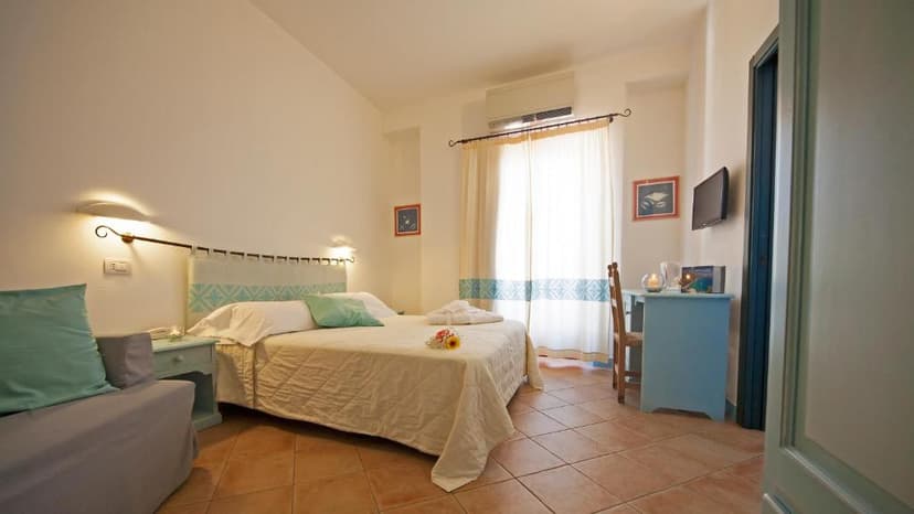 Hotel room with large bed, light blue accents, and terracotta tiled floor in BUE MARINO.