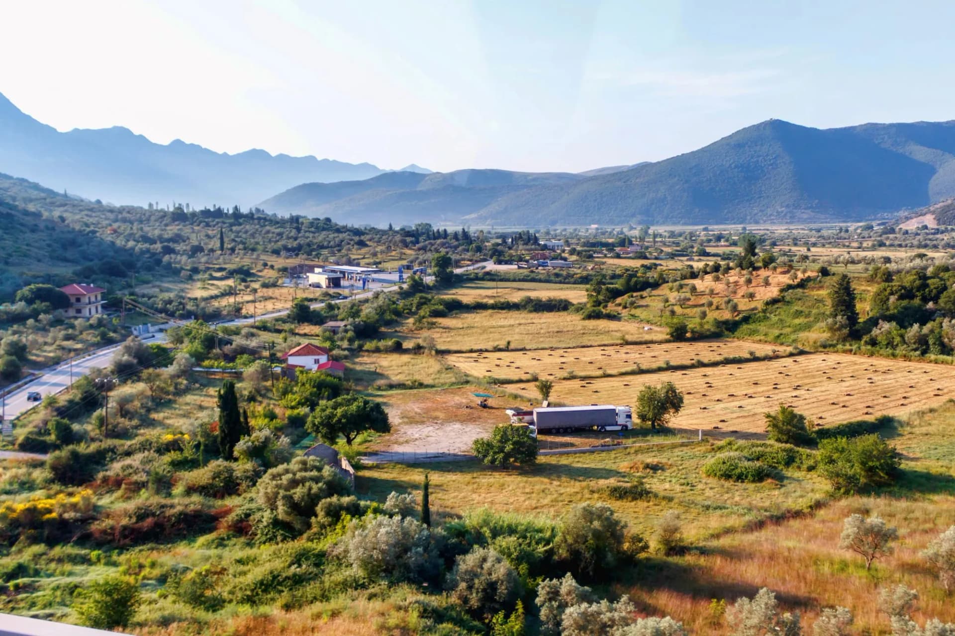 View on fields, houses and green mountains at sunset in Greece, Corfu