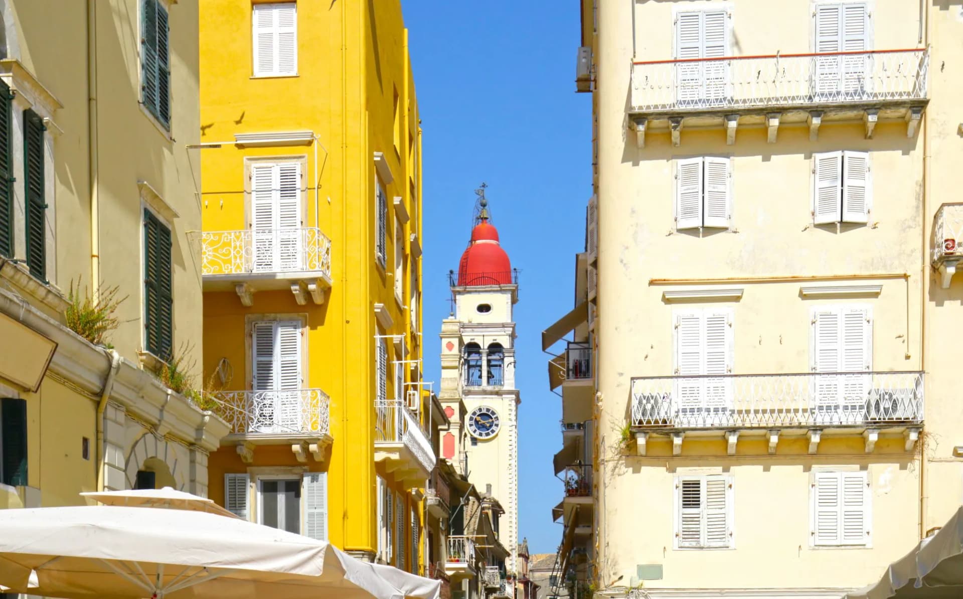 Corfu, Greece. Clock Tower of the Church of Agios Spiridon. Framed amount colorful old buildings in Old town