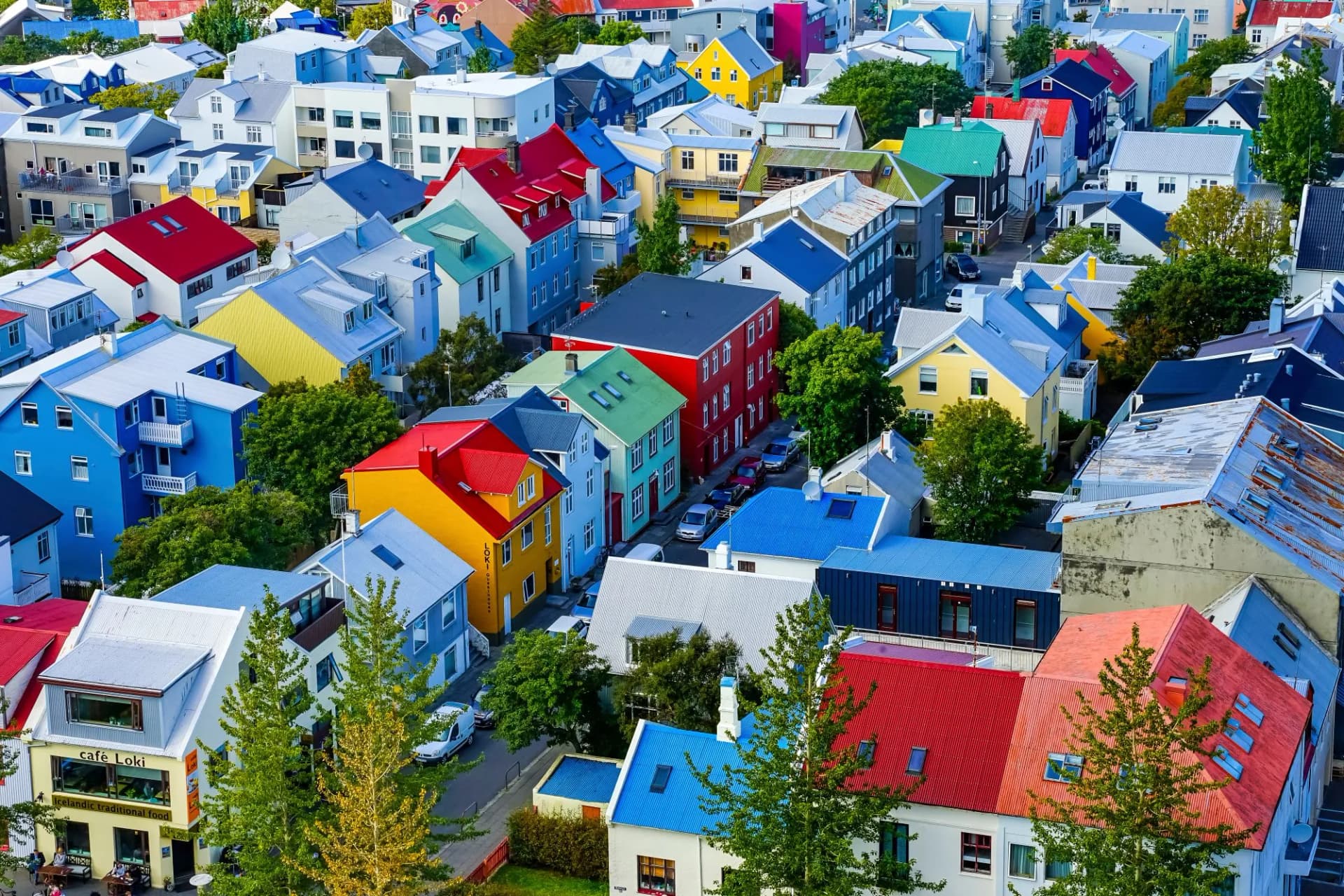Colorful houses with bright roofs in Reykjavik, Iceland, with Cafe Loki visible below.