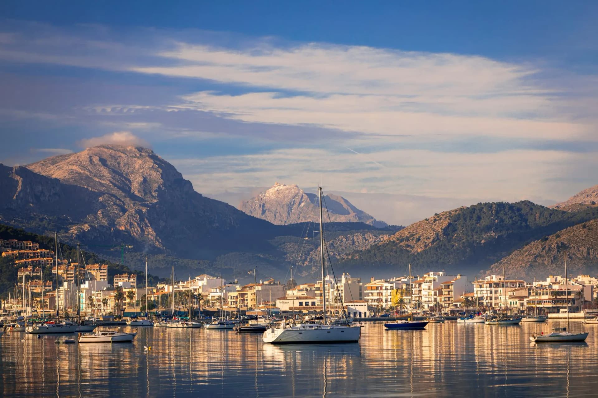 Calm morning walk along the seafront of port de Pollenca Majorca and the magnificent views of the bay and Tramuntana mountains backdrop